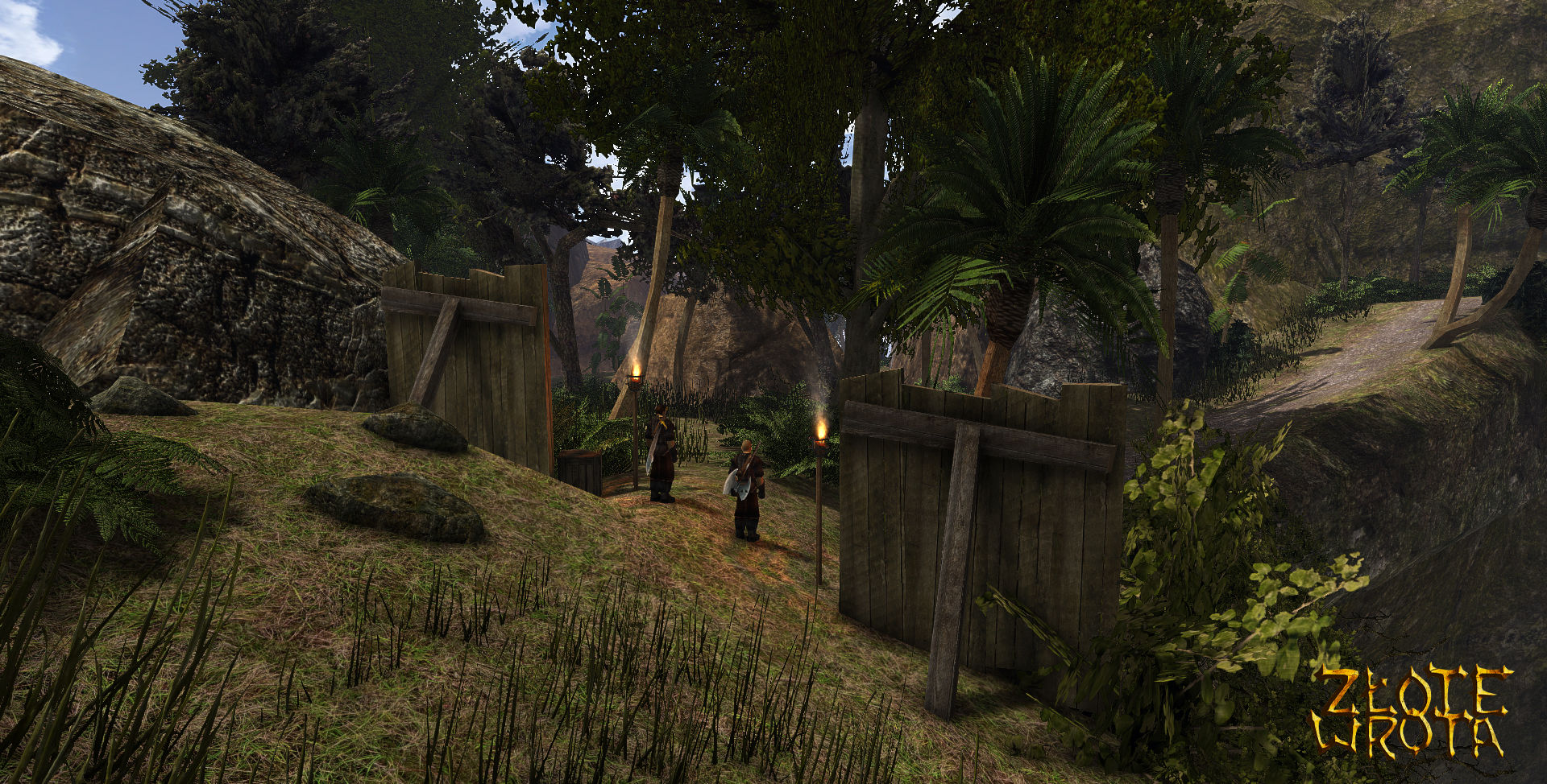 Screenshot der Gothic-2-Mod Das Goldene Tor. Zu sehen ist der Eingang des Piratenlagers in der Nähe des Strands. Das Lager wird von Palisaden geschützt und zwei Piraten bewachen den Zugang. 