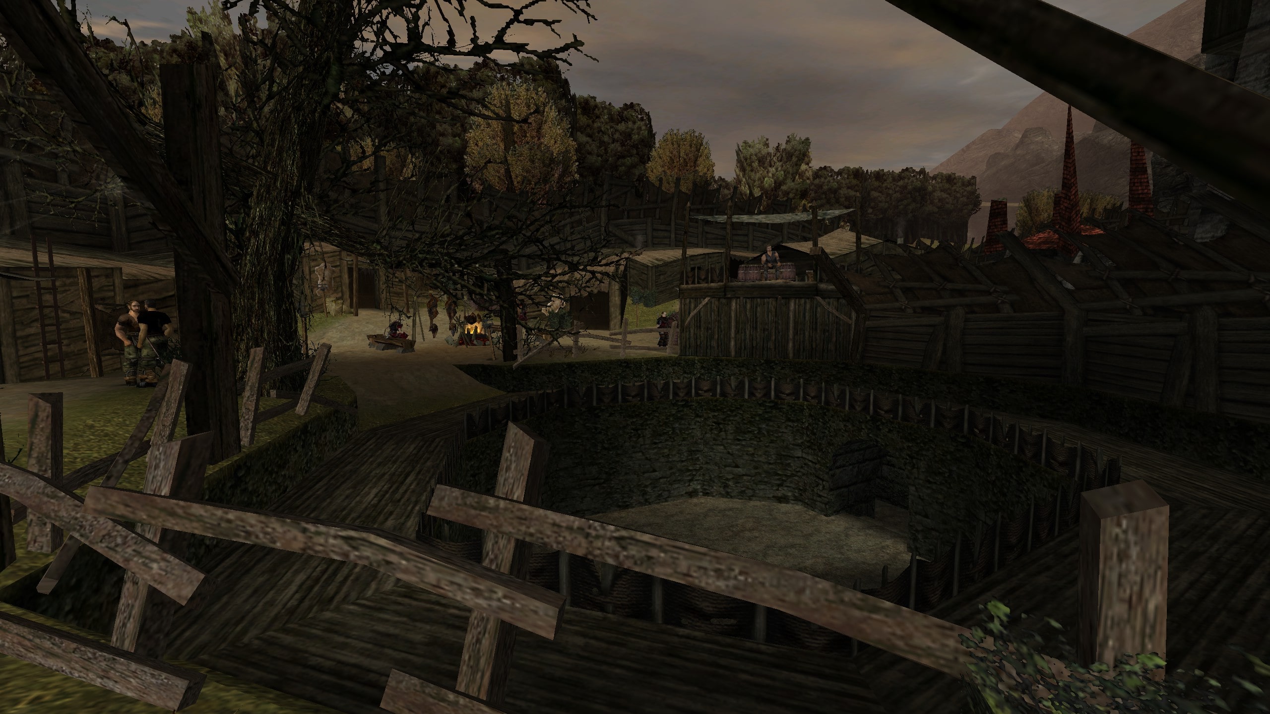 Screenshot aus Gothic 1. Zu sehen ist die Arena des Alten Lagers. Im Hintergrund sind Hütten und Schürfer zu sehen. 