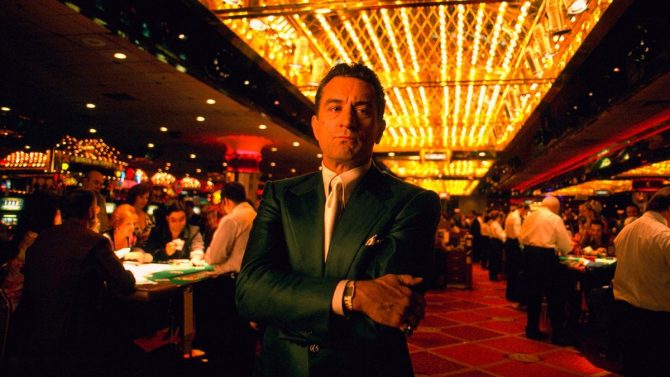 Ein Standbild aus dem Film Casino von 1995. Zu sehen ist Sam Rothstein (Ace), er inmitten eines Casinos steht. Um ihn herum wird Blackjack gespielt.