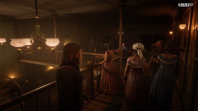 Screenshot aus dem Spiel Red Dead Redemption 2: dargestellt ist ein rauchiger Saloon. Im Hintergrund ist ein Blackjack-Tisch zu sehen.