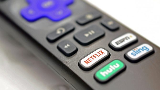 Zu sehen ist eine Smart-TV-Fernbedienung auf welcher unterschiedliche Tasten für verschiedene Streaming-Anbieter im Fokus sind. Besonders hervorgehoben ist die Taste für Netflix.